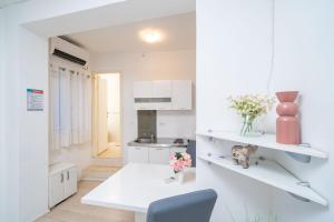 a white kitchen with a table and a chair at Isaura Apartments in Dubrovnik