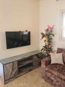 a living room with a flat screen tv on a wall at شاليه مميز جدا فندق ميراج شاطئ كبير in Hurghada