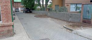 una strada vuota con un muro di mattoni accanto a un edificio di Somos Punto Aparts a El Calafate