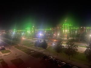 Комфортабельные - Уютные квартиры в городе Костанай (Плаза) في كوستاناي: مدينة مضاءة ليلا مع أضواء خضراء