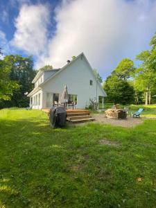 Casa blanca grande con porche y patio en Private Waterfront SPA Perfect Sunsets Lake, en Nominingue