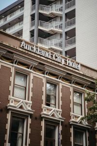 un edificio de apartamentos con un cartel en la parte delantera en Auckland City Hotel - Hobson St, en Auckland