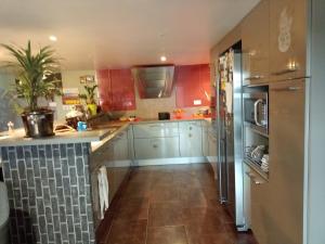 a kitchen with white cabinets and a refrigerator at Comfortable country house in Saint-Beauzély