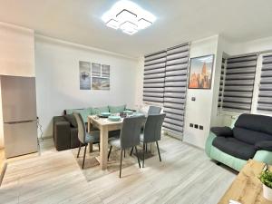 a dining room with a table and chairs and a couch at Best Family Apartment in Varna City