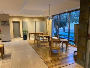 a living room with tables and chairs and a large window at Tierra Mora in San Rafael