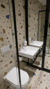 un bagno con due lavandini e parete di roccia di 2E Center Apartment a Tirana Altre 26 foto