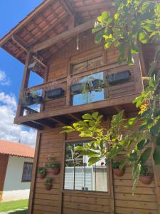 a tree house with a balcony on top of it at Millicent Residence - Chalet Milly e Chalet Iris - Itaoca Praia - ES in Itapemirim