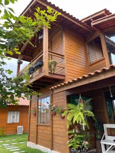 drewniany dom z balkonem w obiekcie Millicent Residence - Chalet Milly e Chalet Iris - Itaoca Praia - ES w mieście Itapemirim