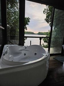 a bath tub in a room with a view of the water at Willo's Treehouse in Escuintla