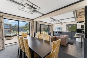 a kitchen and living room with a table and chairs at Alpine Mountain View 39 Ground Floor 3 Bedroom Unit in Jindabyne