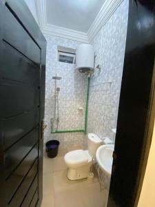 a small bathroom with a toilet and a sink at Charly Cabanadeluxe in Cotonou