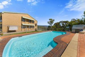 a swimming pool in front of a house at Alpine Mountain View 39 Ground Floor 3 Bedroom Unit in Jindabyne