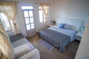 - une chambre avec un lit, un canapé et des fenêtres dans l'établissement Casa Azul Departamentos frente al mar, à Máncora