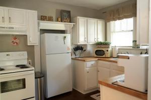 een keuken met witte kasten en een witte koelkast bij Atl Layover #2 - So Fresh And So Clean in Atlanta