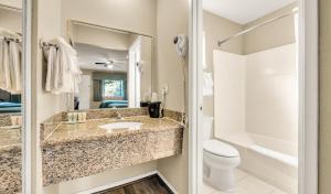 a bathroom with a sink and a toilet and a mirror at Scottish Fairway Inn in Monterey +38 photos