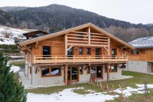 a log home with a mountain in the background at Chalet Prestige Hélios 12 guests in Megève