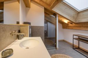 a bathroom with a sink in a room with wooden ceilings at Chalet Prestige Hélios 12 guests in Megève +47 photos