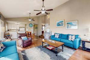 una sala de estar con sofás azules y una mesa. en Sea La Vie, en Port Aransas