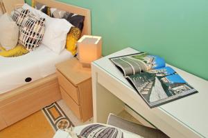 una camera con letto e tavolo con rivista di CASA GIULIANA - 3BR 2BATH, 2nd floor of historic mansion with lift and doorman, comfortable, chic, family friendly, 600 meters from Vatican & Ottaviano metro, quietest area of P R A T I wealthy, secure, accessible district - Warm guest care in 4 languages a Roma Altre 36 foto