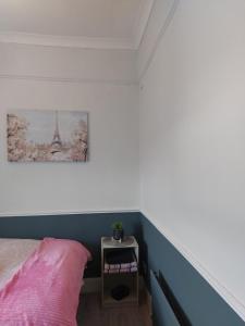 朗福德的住宿－The corner house Longford town，卧室配有粉红色的床,墙上挂着一幅画