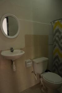 een badkamer met een toilet, een wastafel en een spiegel bij Casa Habitacion, 4 dormitorios in Tarapoto