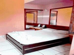 a bedroom with two beds and a mirror at Estalagem Motel (Adult Only) in Rio de Janeiro