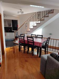 a dining room with a table and chairs and a staircase at Delfina`s House in Machico