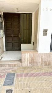 an entrance to a building with a wooden door at Temporarios Calle Formosa in Resistencia