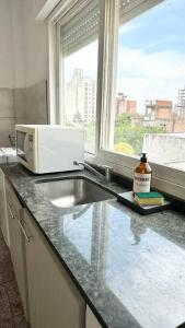 a kitchen counter with a sink and a microwave at Temporarios Calle Formosa in Resistencia