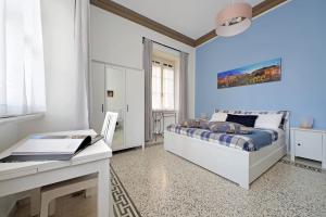 una camera da letto blu con un letto e una scrivania di CASA GIULIANA - 3BR 2BATH, 2nd floor of historic mansion with lift and doorman, comfortable, chic, family friendly, 600 meters from Vatican & Ottaviano metro, quietest area of P R A T I wealthy, secure, accessible district - Warm guest care in 4 languages a Roma