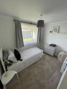 a bedroom with a bed and a window and a chair at Peaceful centrally located, 2 Bedroom Bungalow. in Camborne +19 photos