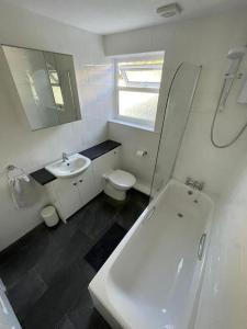 a white bathroom with a sink and a toilet at Peaceful centrally located, 2 Bedroom Bungalow. in Camborne