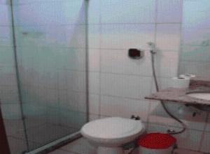 a bathroom with a shower with a toilet and a sink at Estalagem Motel (Adult Only) in Rio de Janeiro