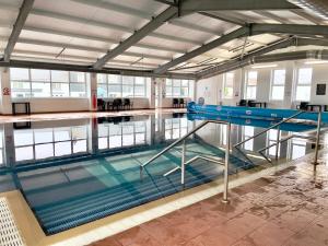an empty swimming pool with water in a building at Lodge with sea & country views in Newquay