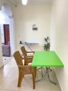 a green table and two chairs in a room at Jerash Heart in Jerash