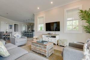a living room with two couches and a tv at Springtide House -Dock & Home w Pool in Stock Island +41 photos