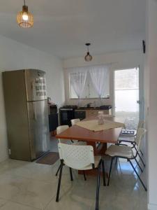 a kitchen with a table and chairs and a refrigerator at Casa da Dinda in Penha
