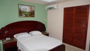 a bedroom with a bed with a wooden headboard at Residencial El Amanecer in Panama City