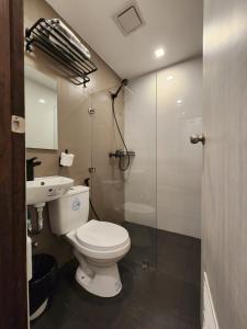 uma casa de banho com um WC e uma cabina de duche em vidro. em Islas Moriones Beach Resort em Maniwaya