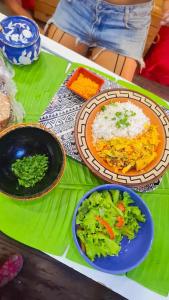 a table with plates of food and a plate of rice and vegetables at Casa Por do Sol in Rio de Janeiro