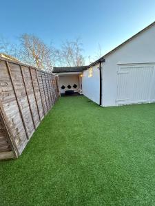 une cour avec une clôture et de l'herbe verte dans l'établissement Hertford HOME, à Hertford