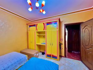 a bedroom with a bed and a colorful cabinet at Luxury 5 star apartment with rooftop, security in Maḩallat al Burj
