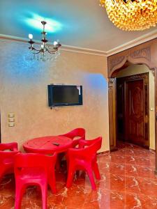 a dining room with a red table and red chairs at Luxury 5 star apartment with rooftop, security in Maḩallat al Burj