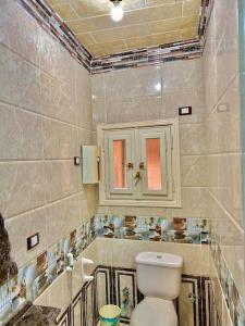 een badkamer met een toilet en een wastafel bij Luxury 5 star apartment with rooftop, security in Maḩallat al Burj