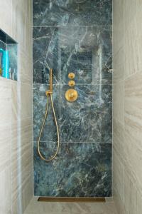 um chuveiro na casa de banho com uma parede em mármore em Apartment Heart of Rotterdam em Roterdã