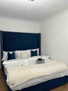 1 dormitorio con 1 cama grande y cabecero azul en Luxury SuperKingsize Bed in London, en Londres