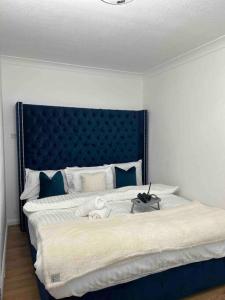 a bedroom with a large bed with a blue headboard at Luxury SuperKingsize Bed in London in London