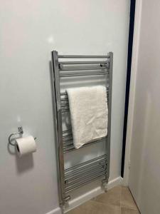 a towel rack in a bathroom with a roll of toilet paper at Luxury SuperKingsize Bed in London in London
