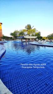 - une grande piscine revêtue de carrelage bleu dans l'établissement Guarajuba Paraíso das Águas A004, térreo - GUARAJUBA TEMPORADA, viva mais de uma experiência de hospedagem conosco!, à Guarajuba