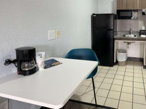 uma cozinha com uma mesa branca e um frigorífico preto em Studio 6-West Palm Beach, FL em West Palm Beach